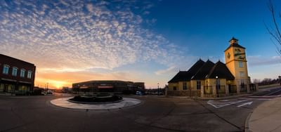 Sunset over a circular drive featuring the Wildwood Hotel with textured clouds filling the sky