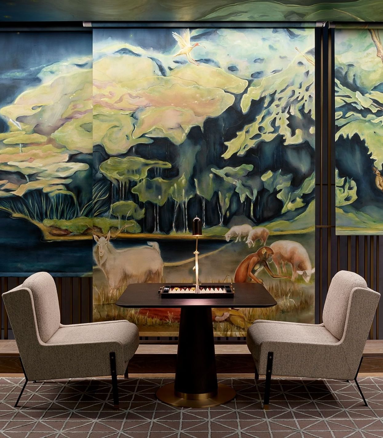 An elegant lounge at The Londoner Hotel with striking nature-inspired murals and comfortable seating