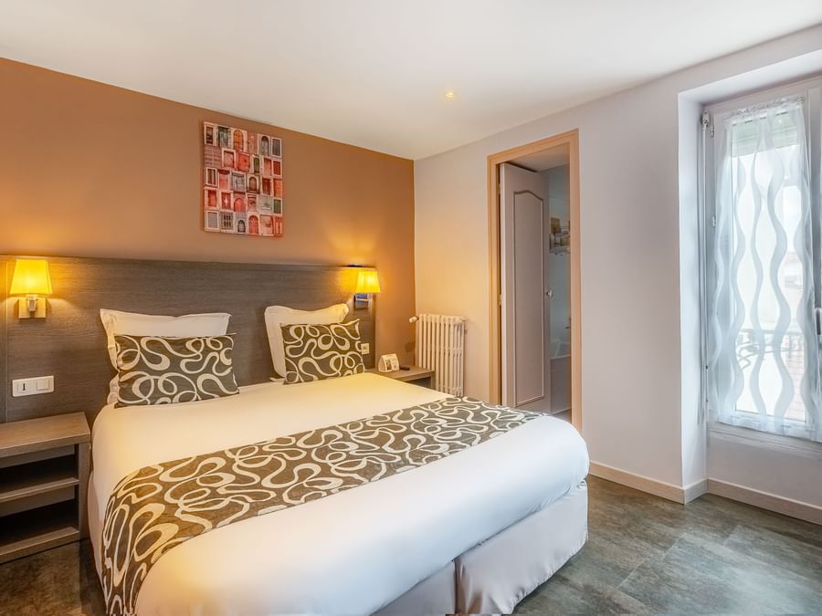 Double bed & bathroom in a room at Originals Hotels
