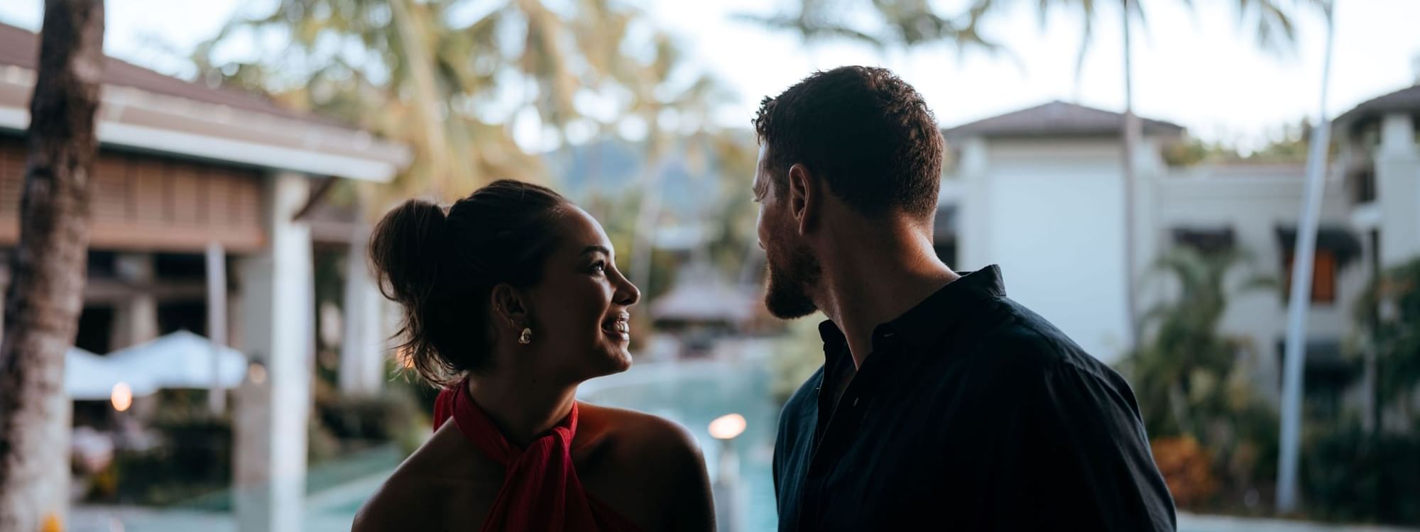 Two people conversing near pool at Pullman Port Douglas Sea Temple Resort & Spa