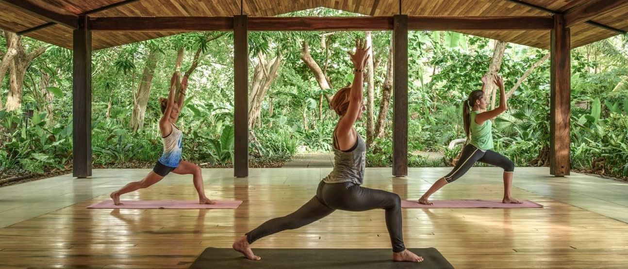 Three women practicing yoga at the Cala Luna Hotel Boutique in Costa Rica.