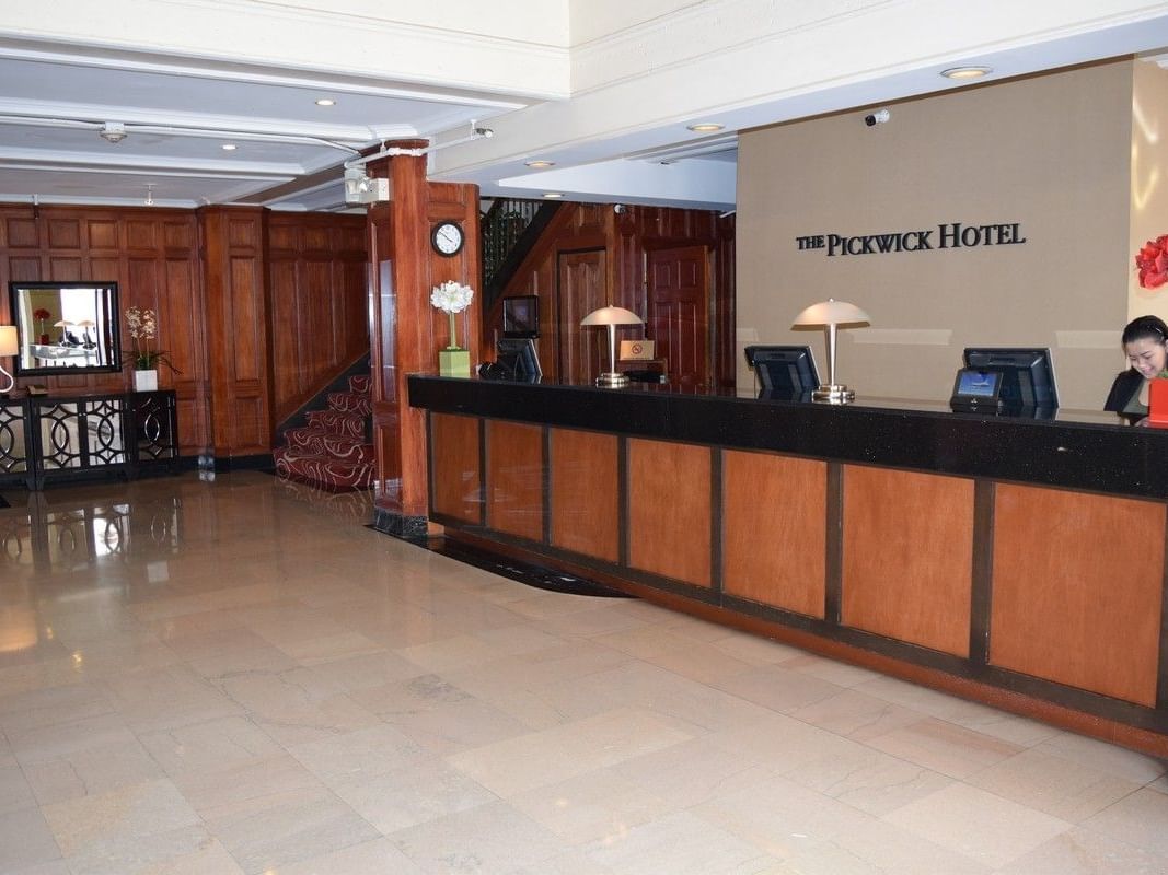 Woman at reception desk in lobby at The Pickwick Hotel.