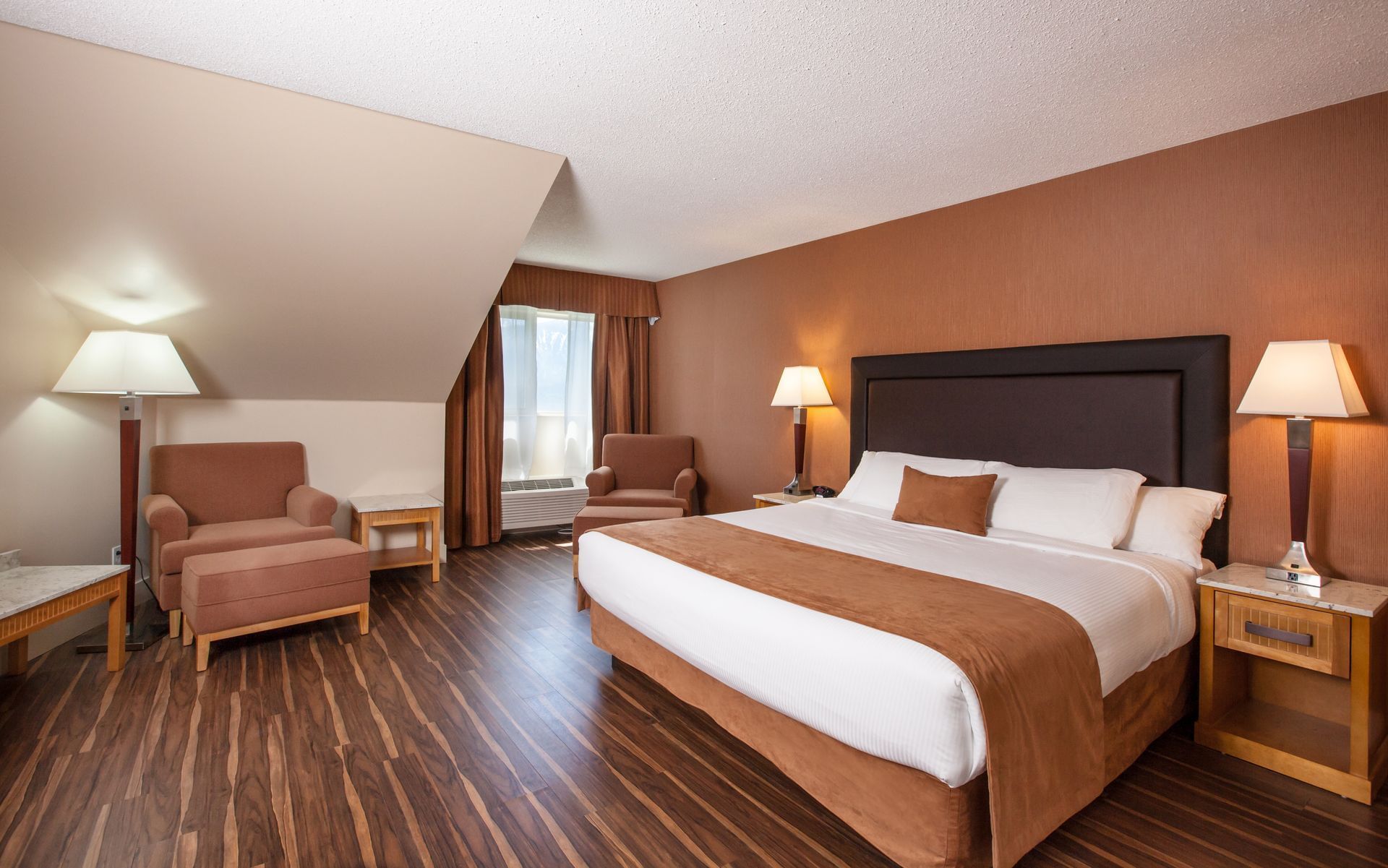 Bed in hotel room with wooden floors