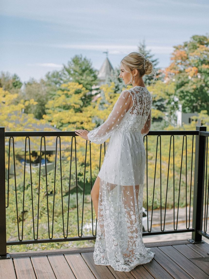 Bride posing by the balcony with lush greenery view at The Earl