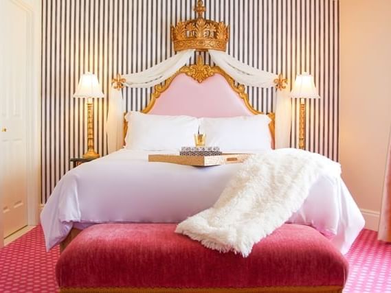 King bed, bench and striped walls at Mission Inn Riverside