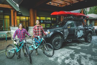2 men posing with bicycles by the entrance, Aava Whistler Hotel