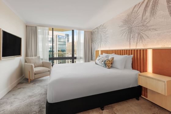 Cozy bed with TV area in a hotel room at Amora Hotel Group