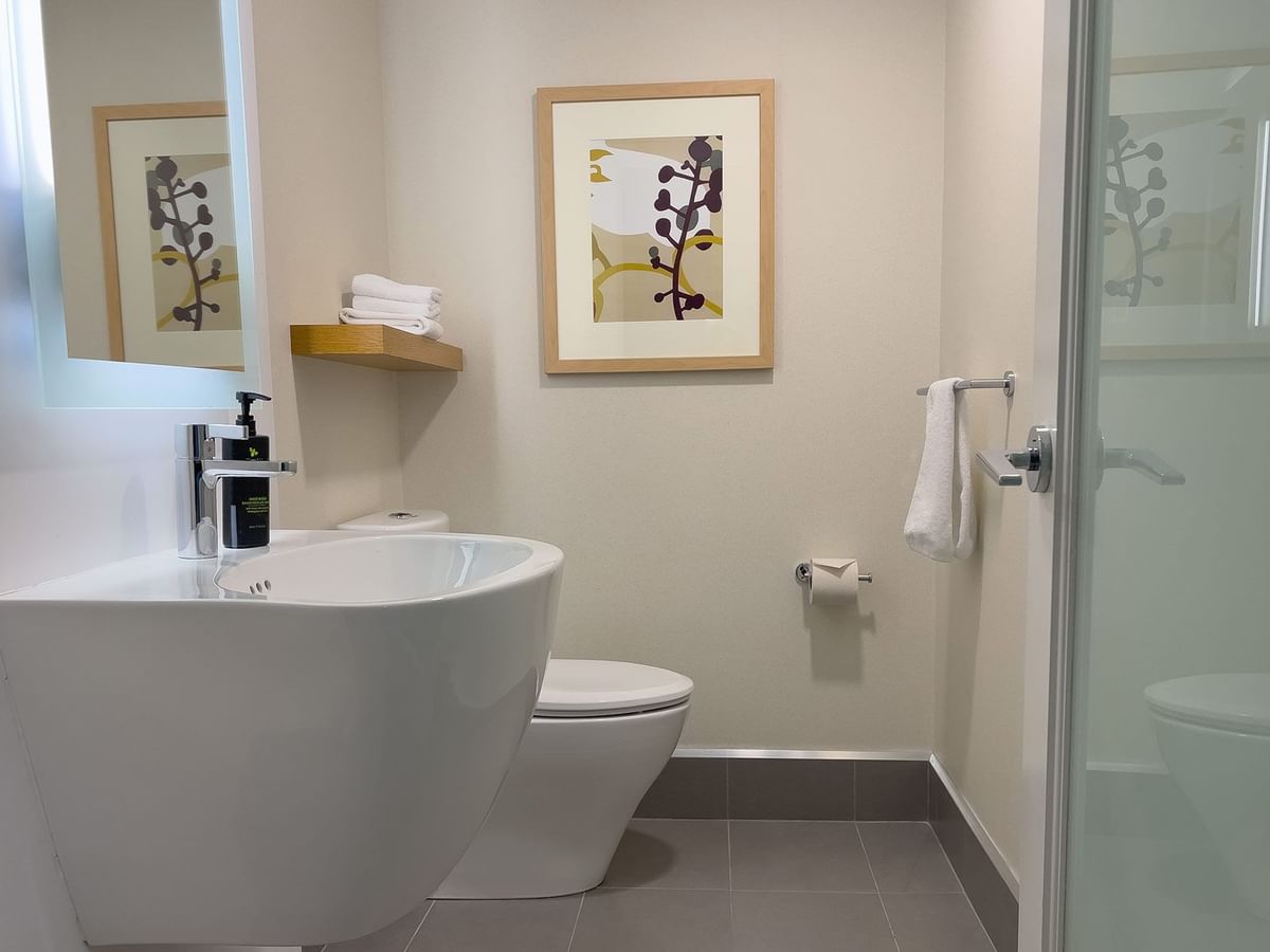 Hotel guestroom bathroom with sink and shower