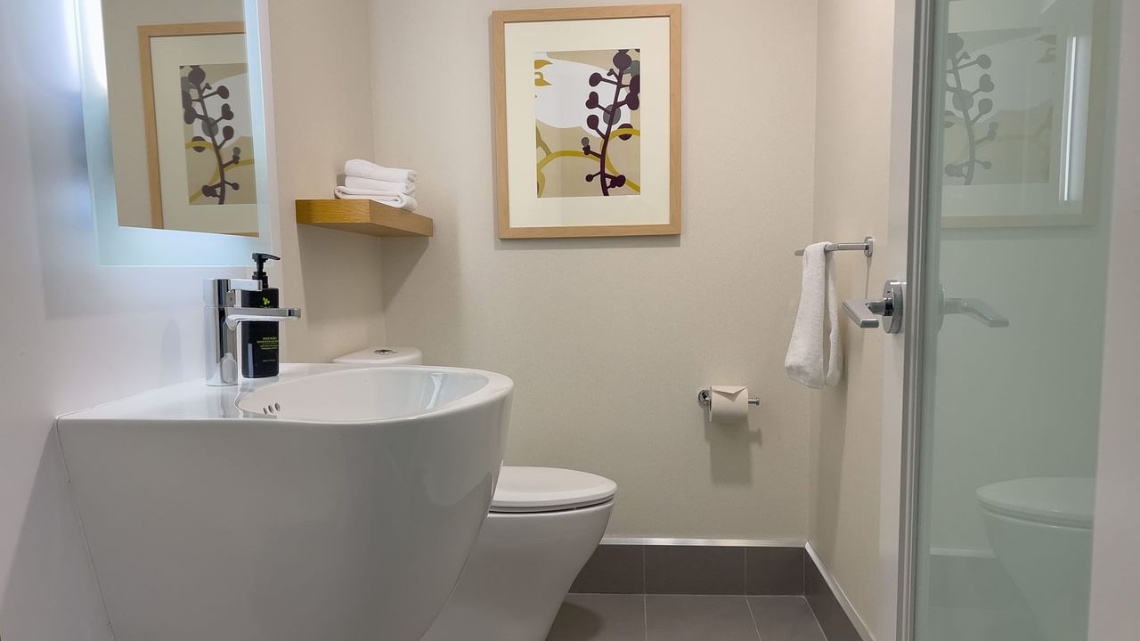 Hotel guestroom bathroom with sink and shower
