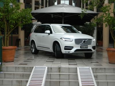 White luxury SUV vehicle parked by the entrance at Amora Hotel