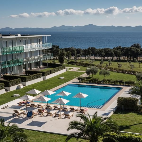 Falkensteiner Hotel & Spa Iadera with balcony facing a pool, sun loungers, and a sea view