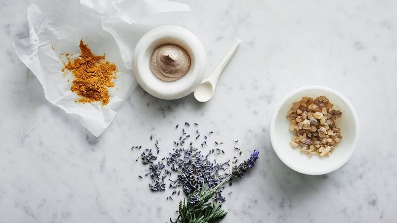 Flat lay of a coffee cup, lavender sprigs, dried petals, sugar and milk on a table in Crown Spa Perth at Crown hotels Perth