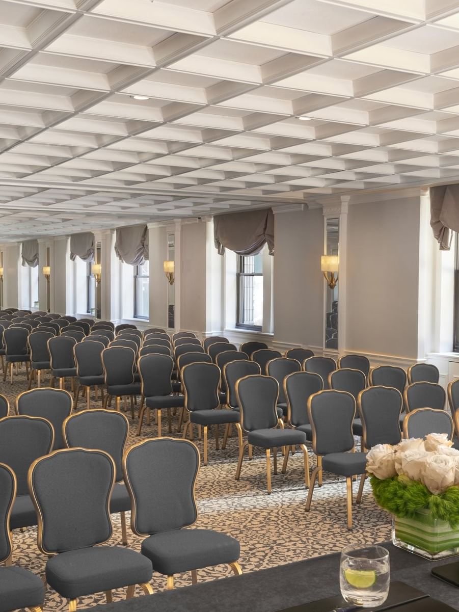 Theater style Kent Surrey Oxford with numerous rows of chairs facing desk on floral centerpiece at Warwick New York