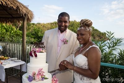 Couple cutting wedding cake at Emerald Beach Resort, celebrations at a St. Thomas resort for beach weddings on Lindbergh Bay