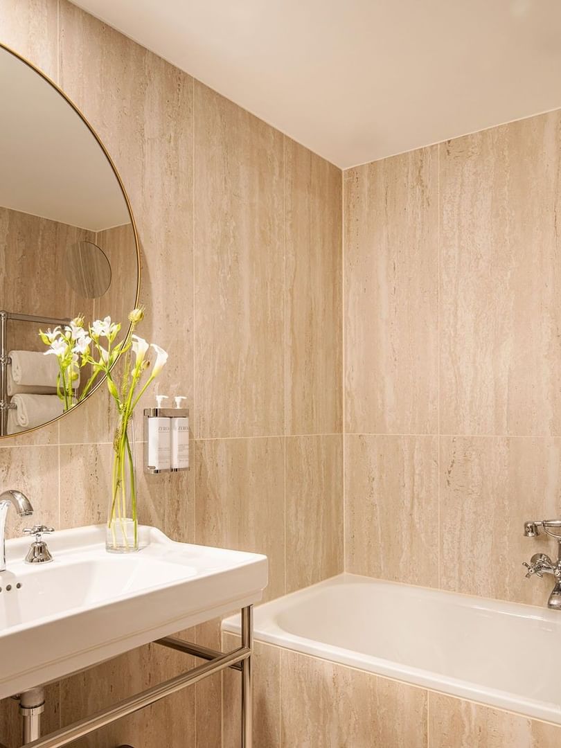 Luxe badkamer met ligbad, wastafel, en grote spiegel in Warwick Suite bij Hotel Barsey by Warwick Brussel.