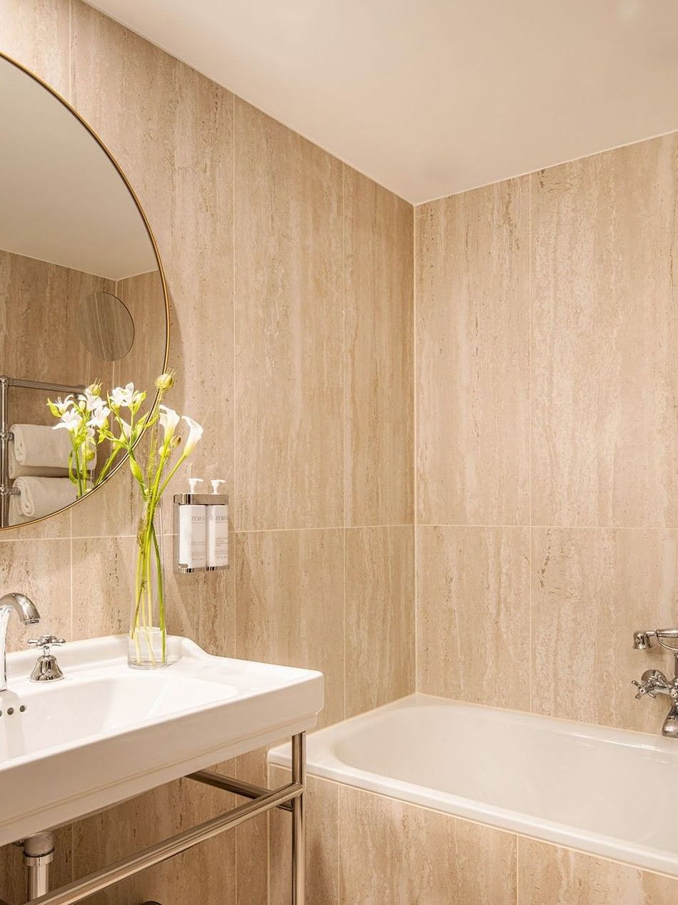 Luxe badkamer met ligbad, wastafel, en grote spiegel in Warwick Suite bij Hotel Barsey by Warwick Brussel.