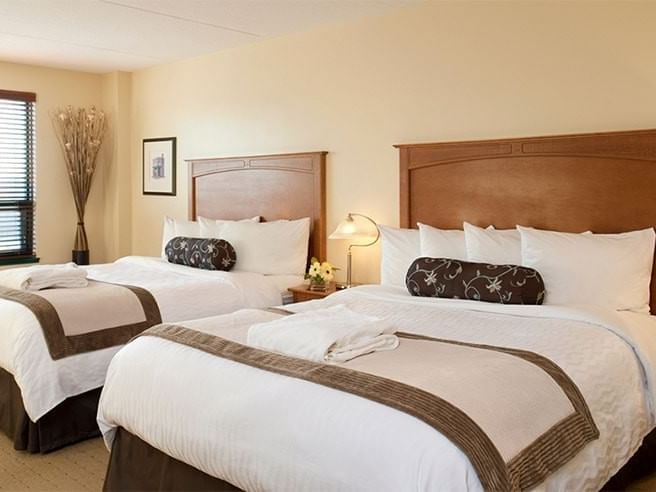 Cozy beds by the nightstand in Standard Two Queen Beds at Temple Gardens Hotel & Spa