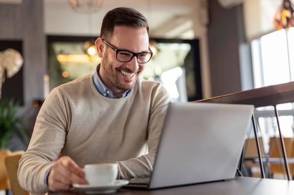 A man working with laptop and having a cup of coffee