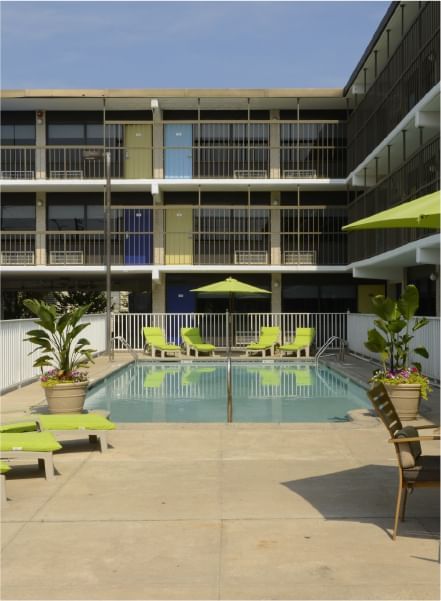Outdoor pool with sunbeds & dining table at Block Party Hotels