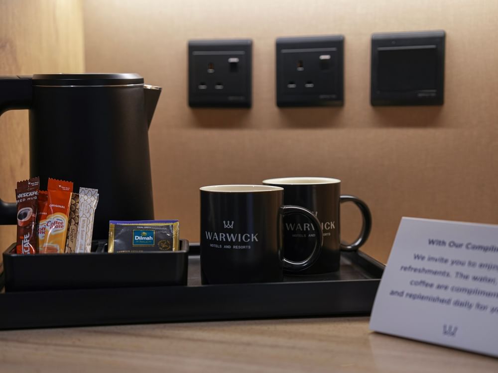 Electric kettle, coffee, tea, and a hospitality tray in a Deluxe Room at Warwick Hotel & Spa - Jeddah.