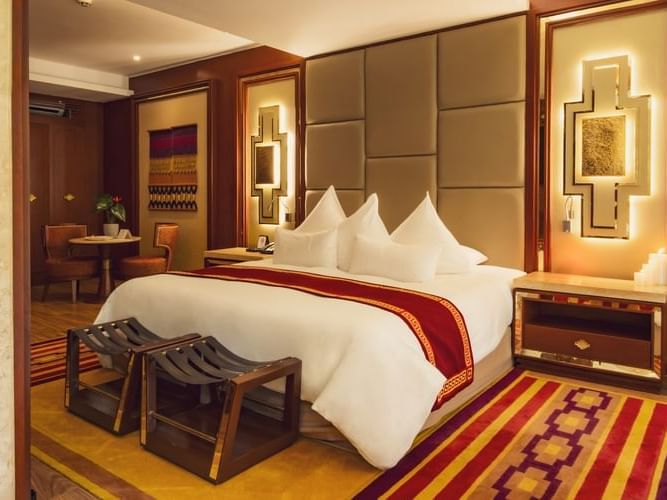 Junior Suite with River View featuring a king bed with decorative runner and upholstered headboard at Sumaq Machu Picchu Hotel