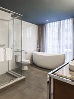 Warwick Premier Suite bathroom featuring a bathtub and a glass shower at Warwick Le Crystal Montreal