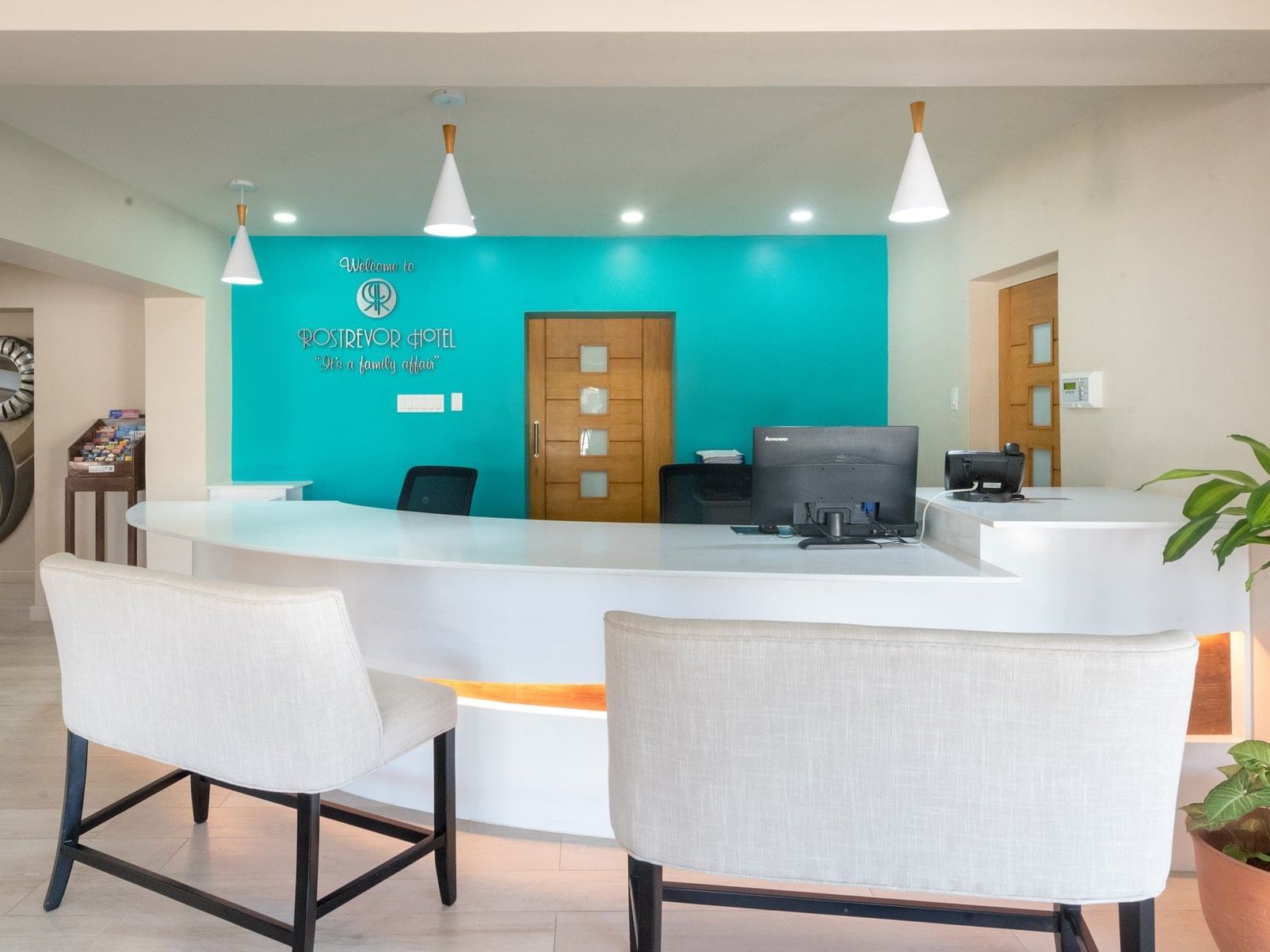Modern lobby area with reception desk and white chairs at Rostrevor Hotel
