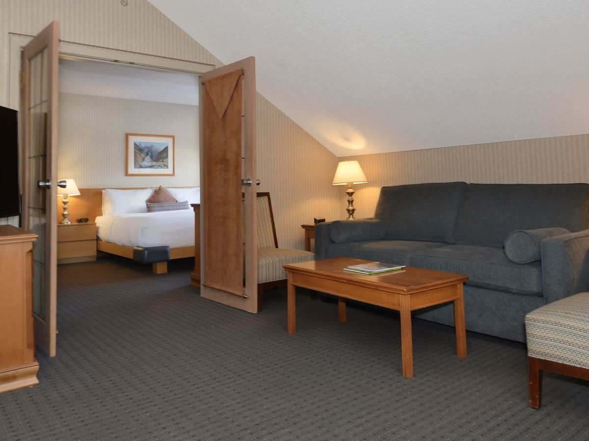Spacious hotel suite with a king bed, elegant decor, sofa bed and HDTV.