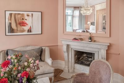 Pink living room with fireplace and vanity mirror at The Sparrow Hotel