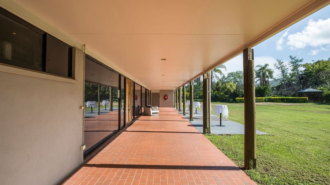 Spacious Ballroom verandah with tiled flooring, leading to a lush green yard at Mercure Hotel Townsville