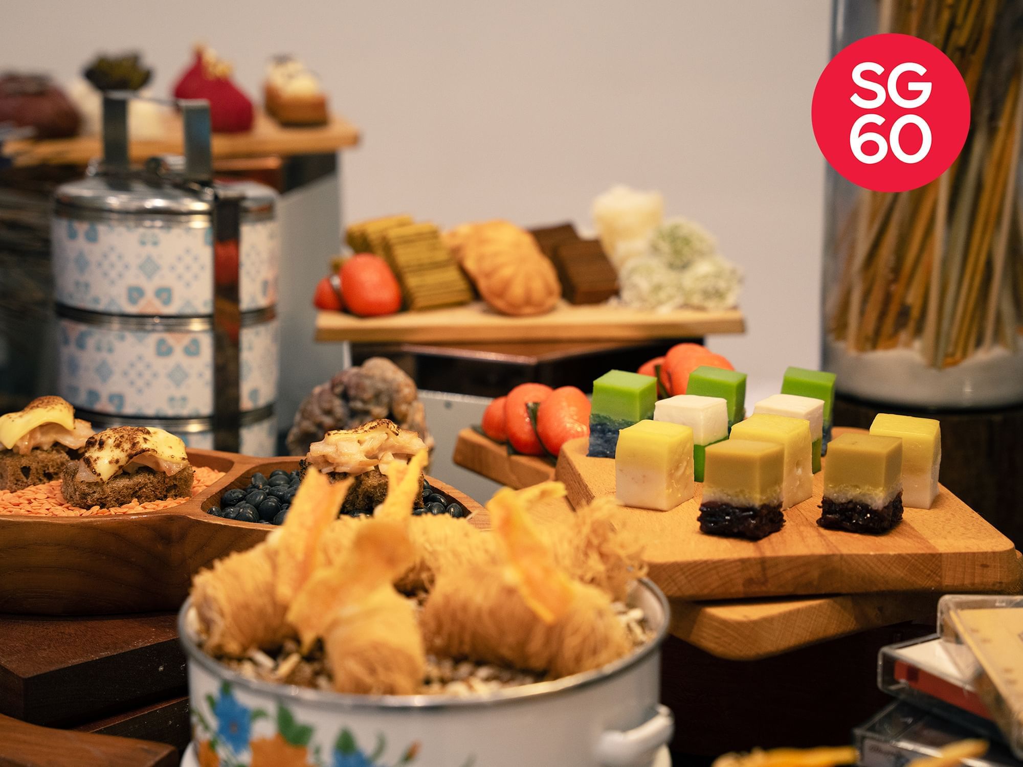 A variety of local Singaporean favourites beautifully arranged on a table for the SG60 celebration, showcasing vibrant and iconic dishes.