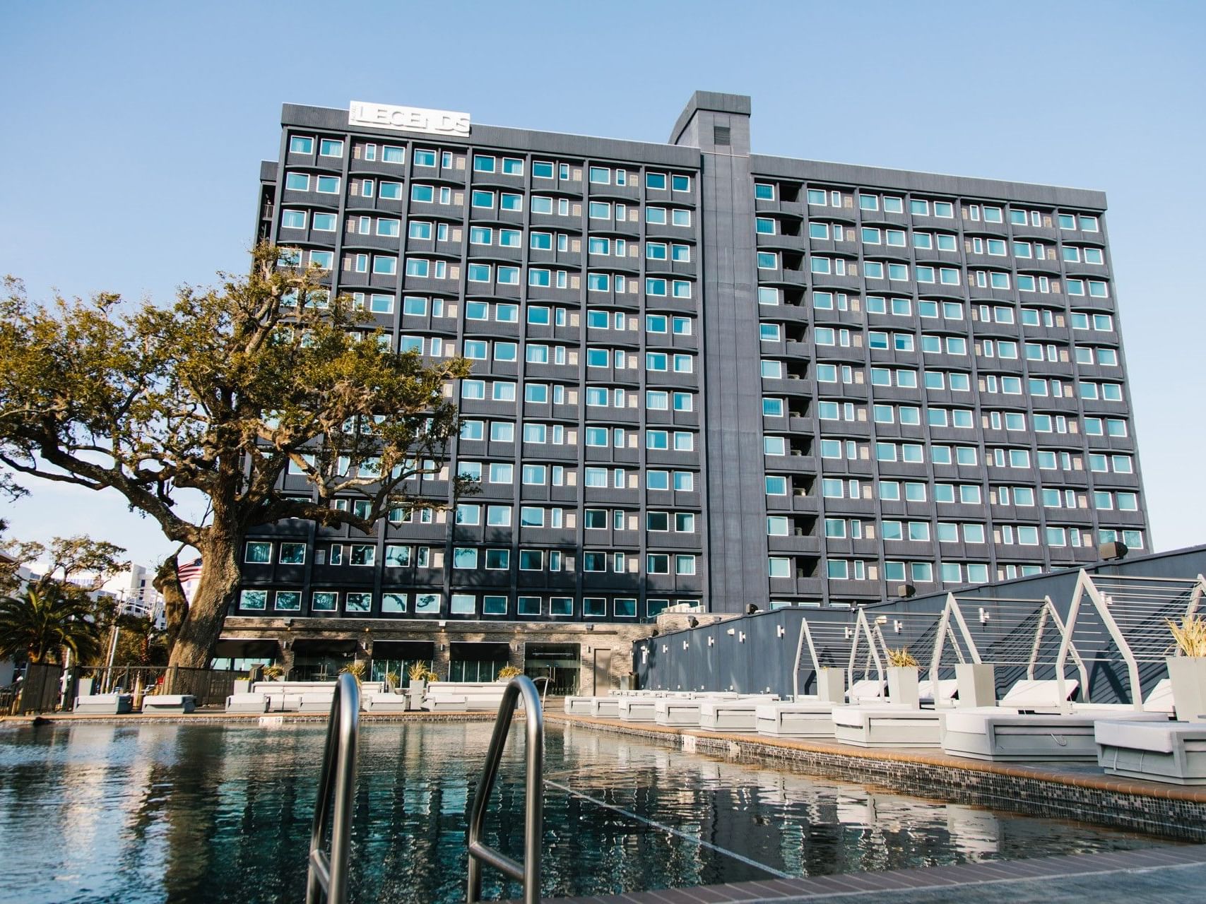 Modern pool area and exterior of the Legends hotel building, located near Margaritaville Resort Biloxi