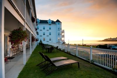 Outdoor lounging area with a view of the ocean at sunset in Union Bluff Hotel