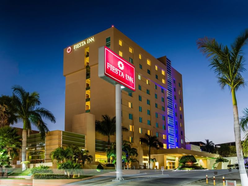 Exterior evening view of Fiesta Inn Tuxtla Gutiérrez & car park
