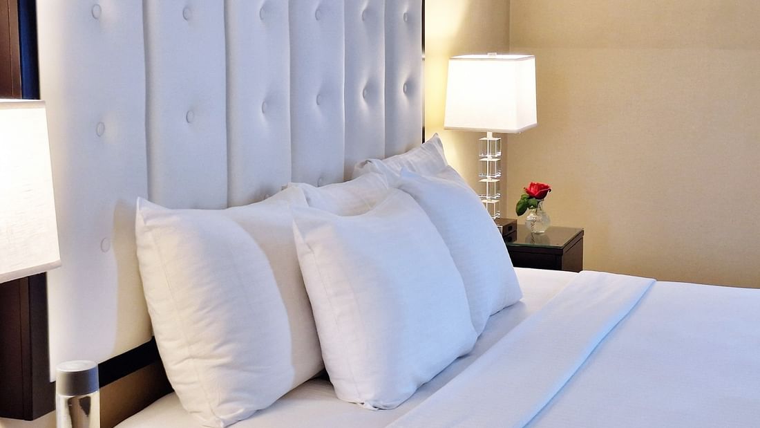 Close-up of bed with table lamp on the side table in Superior Suite at Warwick Allerton Chicago