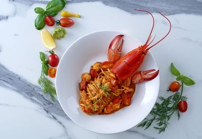 Vibrant bowl of lobster linguine, garnished with fresh herbs and colorful vegetables in Opera Restaurant at Park Hyatt Saigon