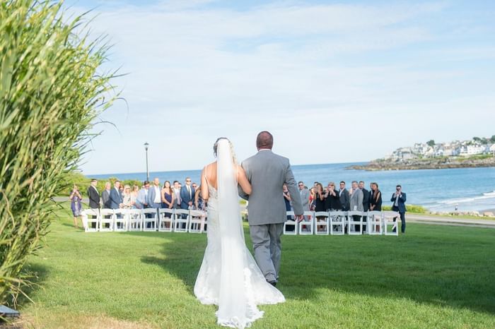 Father walking bride down the aisle with a sea view at Ogunquit Collection