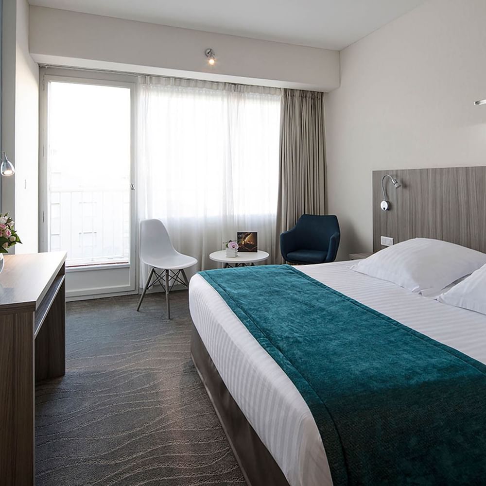 Harmony Room with a plush bed, teal runner, and bright natural balcony light at Splendid Hotel & Spa Nice