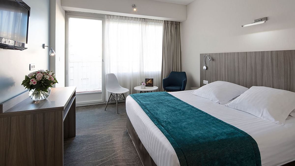 Harmony Room with a plush bed, teal runner, and bright natural balcony light at Splendid Hotel & Spa Nice