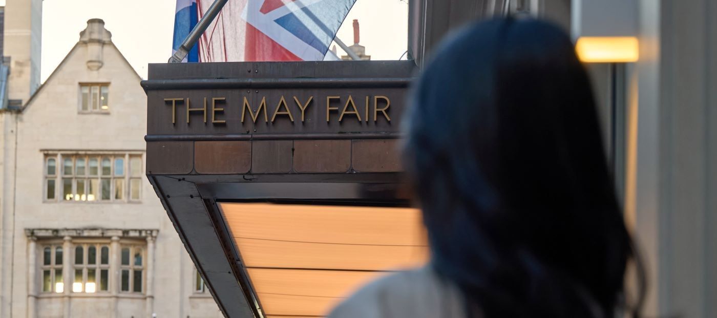 Woman with dark hair standing in front of The May Fair Hotel in London.