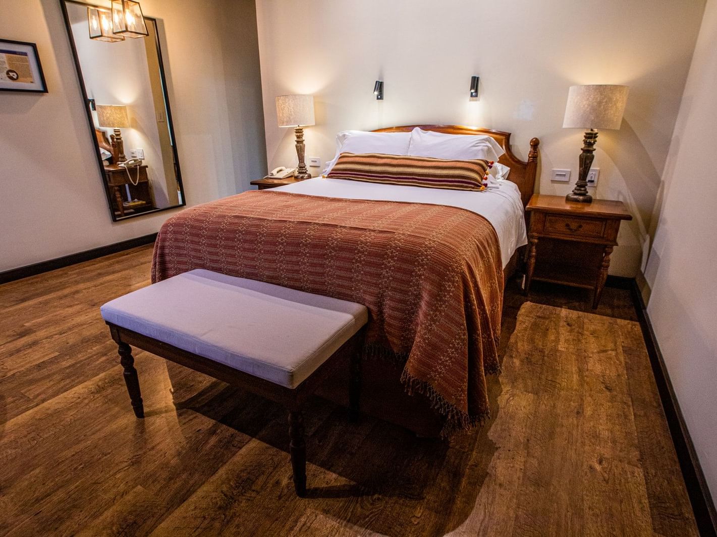 Nightstands by queen bed in Deluxe Executive with wooden floors at Porta Hotel Antigua