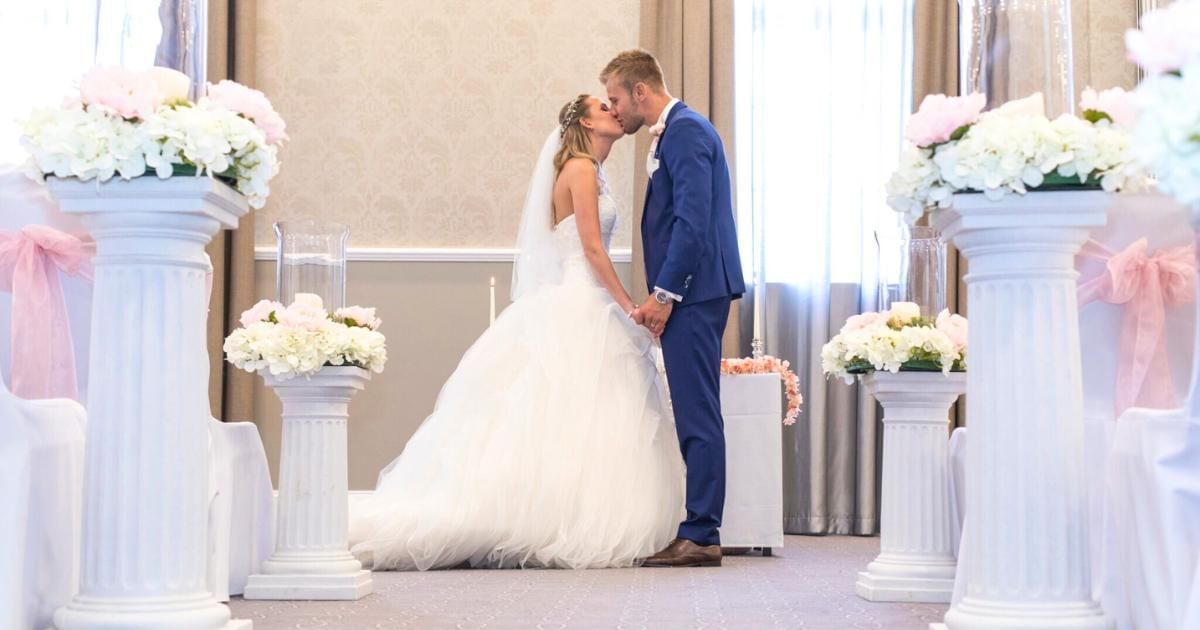 Bride and groom kissing in grand ballroom at Villiers Hotel , wedding venue in Buckinghamshire