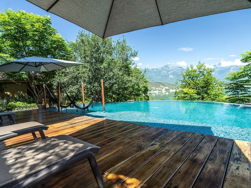 Infinity pool view by sunbed with mountain view at Gamma Hotels