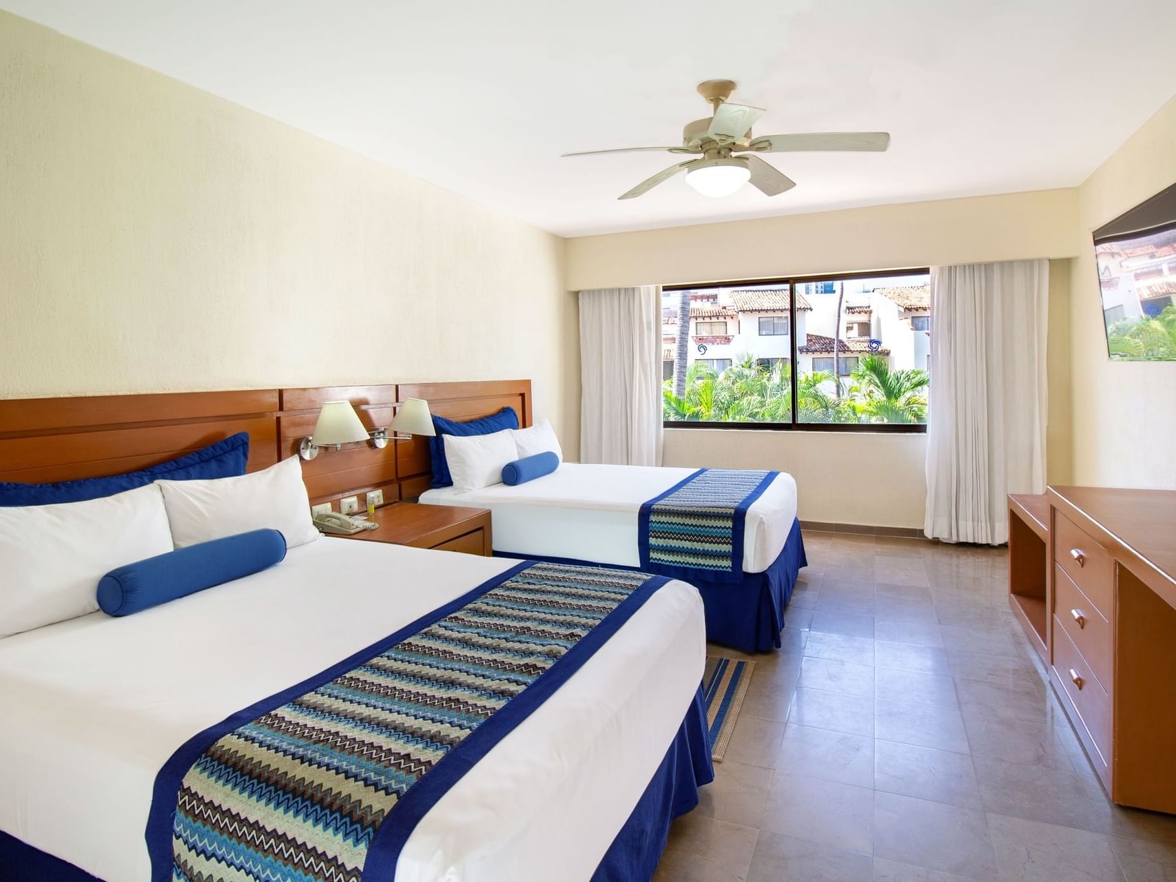 TV facing by the beds in 2 Bedroom Family Suite, Pool View at Plaza Pelicanos Grand Beach Resort