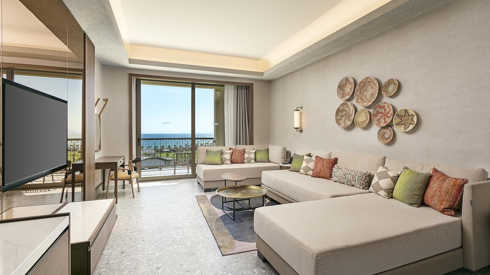 Living area with a big sofa, sea view from the balcony, and a TV in Grand Family at Cullinan Belek