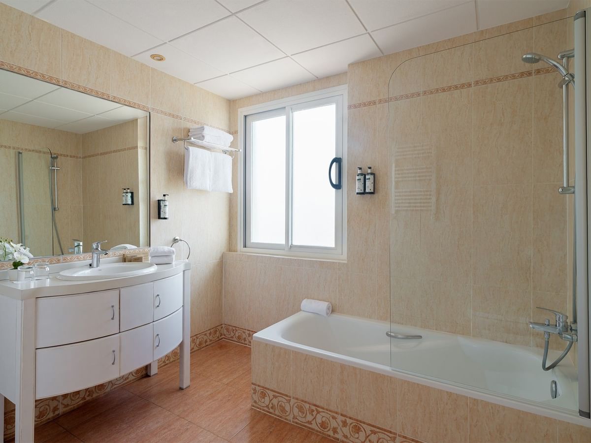 Junior Suite Rooms bathroom featuring a large mirror over a double vanity, a window, and a bathtub at Ponient Pirámide Salou