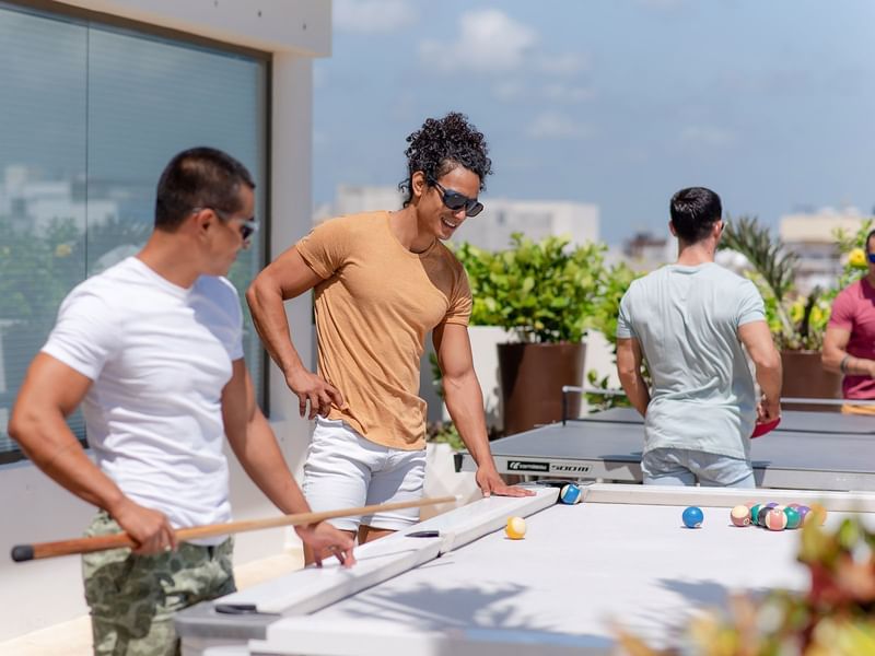 Group of Guys playing pool outdoors at The Reef 28