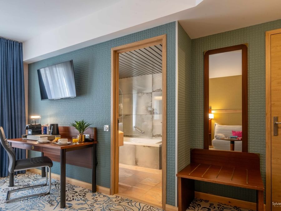 Salle de bains avec baignoire et chambre au Hôtel Le Yachtman.