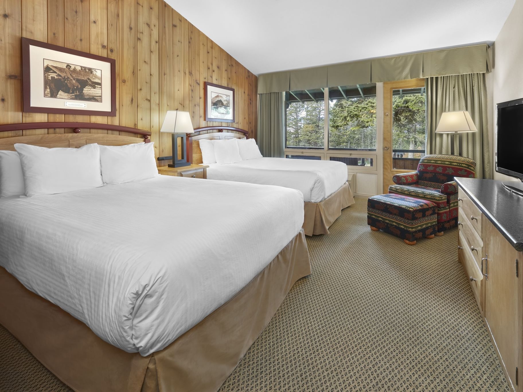 Cozy bed arranged with TV in Classic 2 Queen with A View at Fairmont Hot Springs Resort