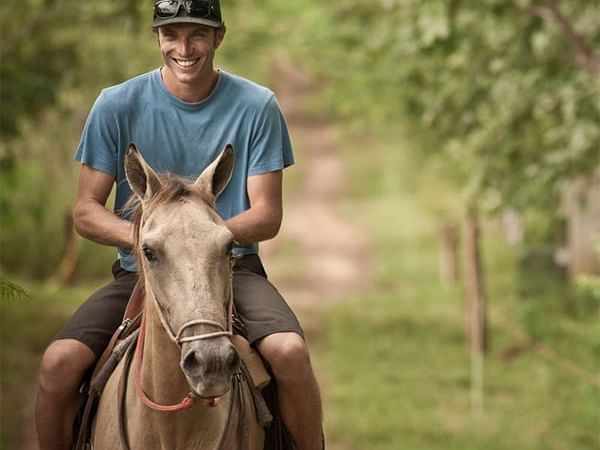 Man horseback Riding in lush hill near Cala Luna Boutique Hotel